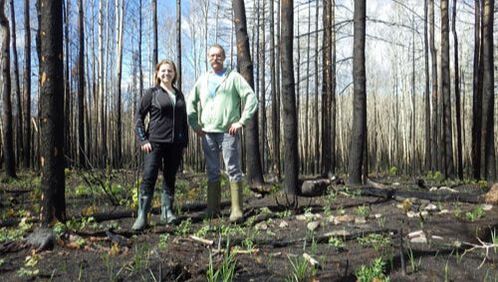 Monica Emelko and Udlis Silins in front of a burnt forest collecting samples
