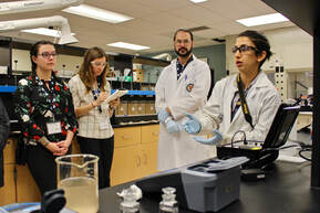 Two students teaching other students about water quality tests in the lab